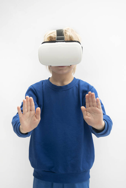 Child plays in virtual reality game with VR glasses. White background. Vertical frame - Foto, afbeelding