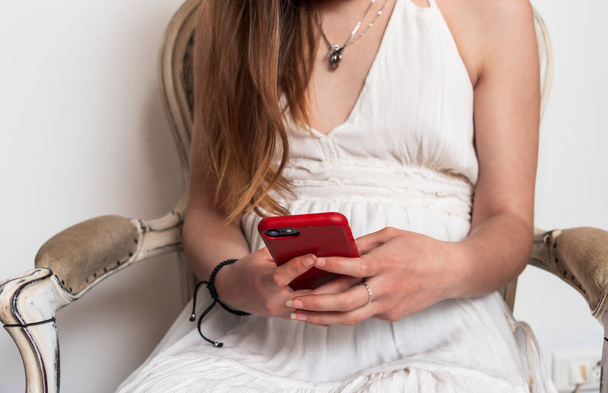 Fiatal nő nézi a mobiltelefon üzenetküldés és szörfözés az interneten . - Fotó, kép