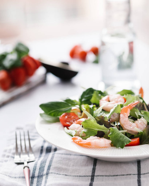 Salad with Tomatoes , berry , vegetables . Bright wooden background. shrimps souse  - Фото, изображение
