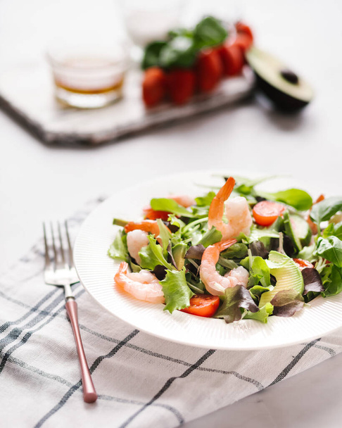 Salad with Tomatoes , berry , vegetables . Bright wooden background. shrimps souse  - Fotó, kép