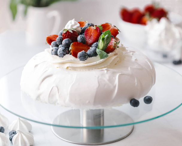 Homemade delicious meringue cake "Pavlova" with fresh straberry and mascarpone on a white background. - Фото, зображення