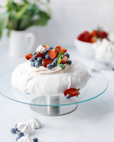 Homemade delicious meringue cake "Pavlova" with fresh straberry and mascarpone on a white background. - Photo, image