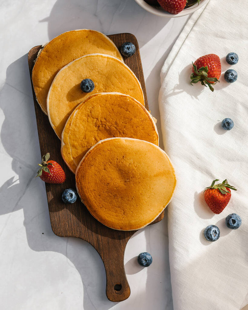 American pancakes on a wooden plate with light background - Fotografie, Obrázek