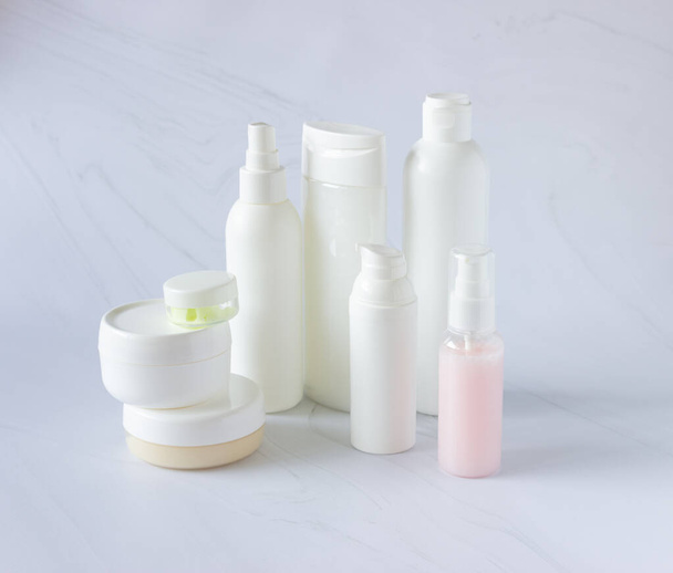 Bottiglie bianche e lattine per cosmetici su fondo chiaro. Pulito, layout e modello - Foto, immagini