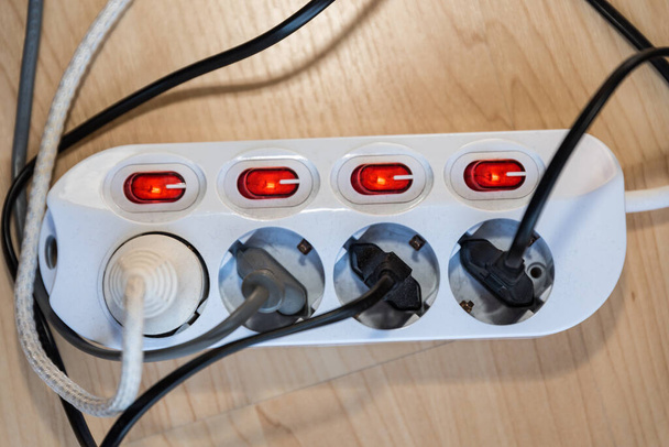Aangeschakeld stopcontact met meerdere stopcontacten - elektriciteitsclose-up - Foto, afbeelding