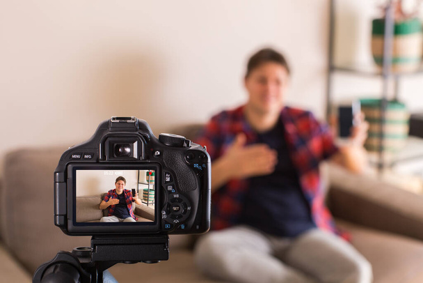 Vlogger grabando video de redes sociales mientras está sentado en el sofá - Foto, imagen