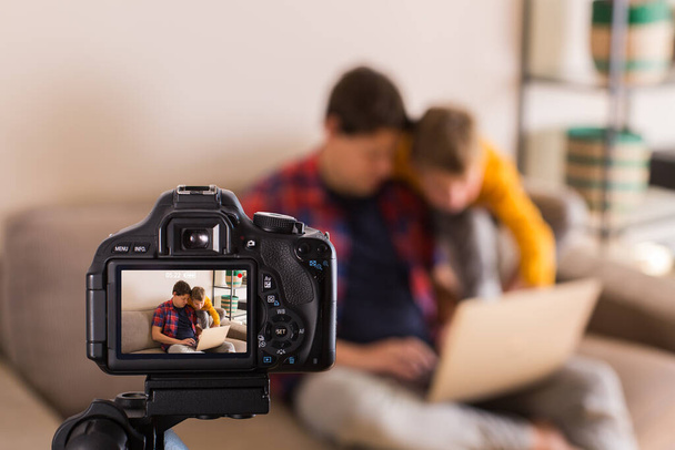 Vlogger οικογένεια καταγραφή βίντεο κοινωνικών μέσων μαζικής ενημέρωσης, ενώ κάθεται στον καναπέ - Φωτογραφία, εικόνα