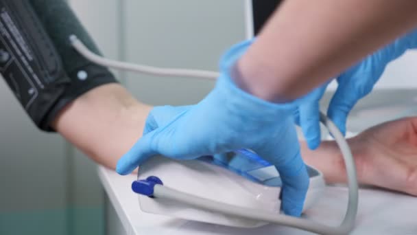 Медсестра надевает наручники на руку, чтобы измерить давление в больнице. - Кадры, видео
