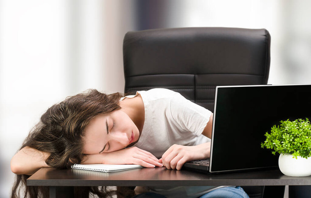 女性は疲れていて家のデスクトップに横たわっています - 写真・画像