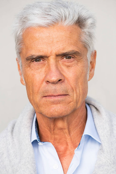Κοντινό πλάνο του όμορφου ηλικιωμένου άντρα με σοβαρή έκφραση - Φωτογραφία, εικόνα
