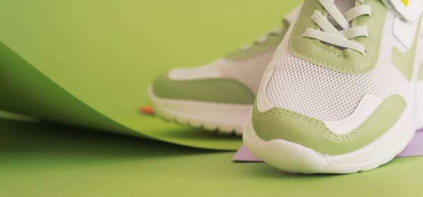 Trendy green shoes on colorful background. Sporty fashionable shoes. - Photo, Image