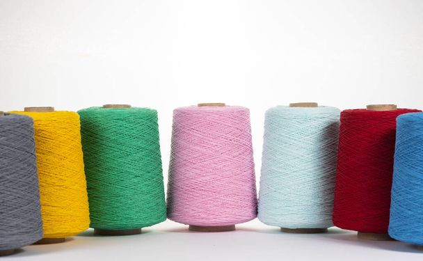 Large multi-colored bobbins with thread on a white background. Space for text - Foto, Bild