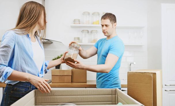 Family couple unpacking boxes after moving to new apartment. - Foto, imagen