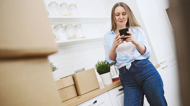 Les femmes communiquent via smartphone après avoir déménagé dans un nouvel appartement. - Photo, image