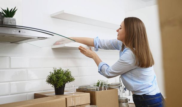 Γυναίκα σκουπίζει την κουζίνα μετά τη μετακίνηση σε νέο διαμέρισμα. - Φωτογραφία, εικόνα