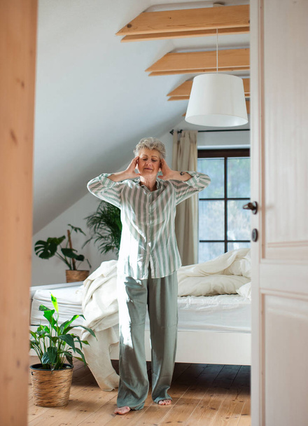 Donna anziana a letto a casa alzarsi la mattina, stretching. - Foto, immagini