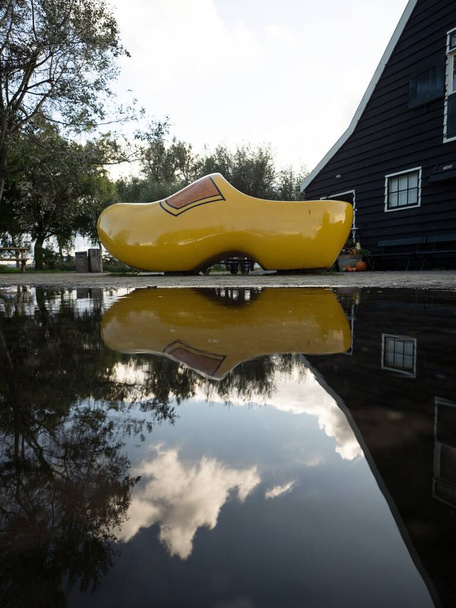 Panoráma tükröződik egy túlméretezett sárga eldugult Klompen cipő cipő cipő Zaanse Schans Zaandijk Amsterdam Észak-Hollandia Hollandia Európa - Fotó, kép
