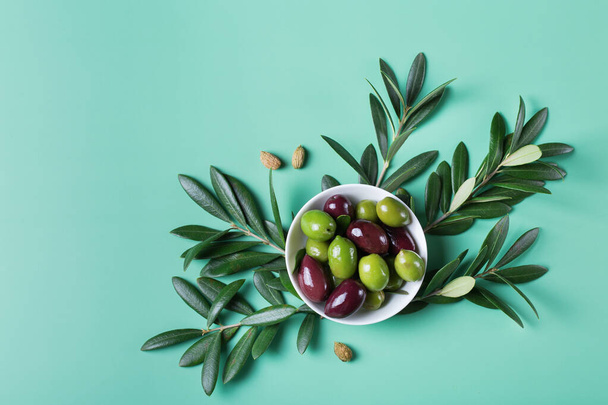 Tuoreet oliivit ja oliivipuun oksa pöydällä - Valokuva, kuva