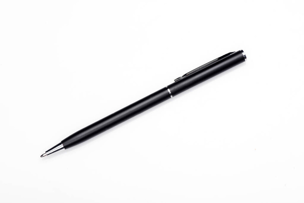 Шариковая ручка на белом фоне, черная металлическая ручка. - Фото, изображение