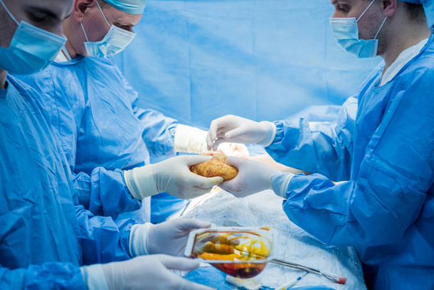 Breast augmentation under the guidance surgeons team in surgical operating room. - Foto, Bild