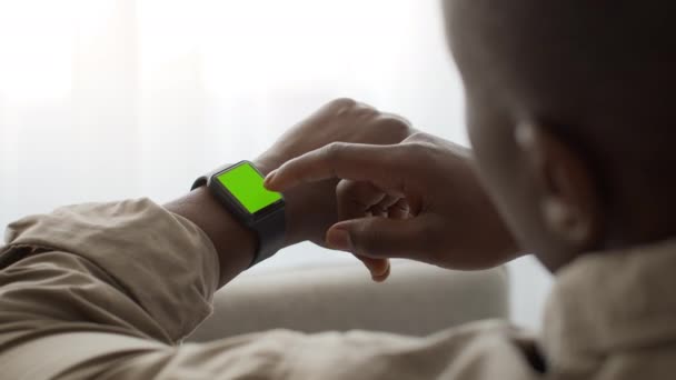 Αφρο-Αμερικανός άνθρωπος κύλιση πράσινο chroma οθόνη κλειδί του smartwatch, ανάγνωση μήνυμα ή τον έλεγχο της υγείας του κατάσταση - Πλάνα, βίντεο