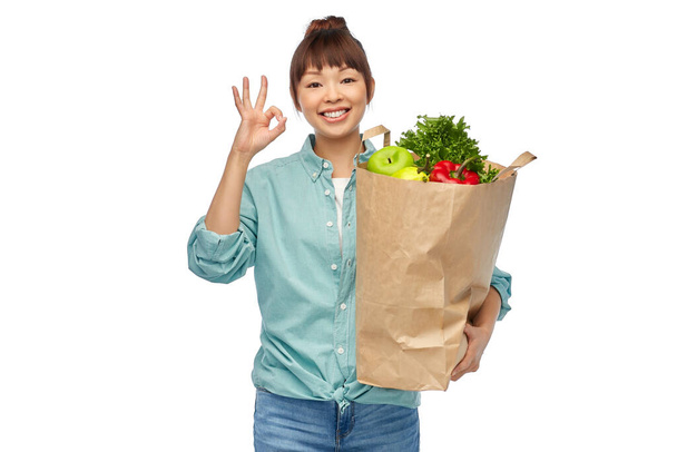 happy asian woman with food in paper shopping bag - Foto, immagini
