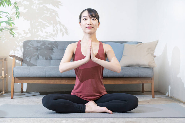 Asiática joven haciendo yoga en la habitación - Foto, Imagen