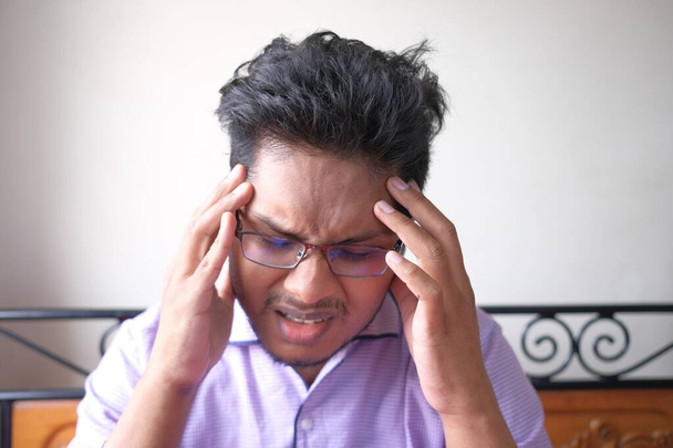 Молодой человек страдает головной болью, закрыть  - Фото, изображение