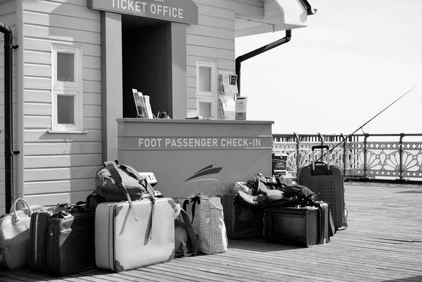 Penarth, Vale of Glamorgan, Wales - April 11 2021. Set designers create a fictional ferry port on Penarth Pier with vintage luggage ready to film episodes of the Netflix series called Sex Education - Photo, Image