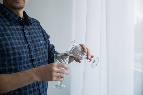 a man in a blue shirt holds empty glasses of vitiligo photo from the front - Photo, image