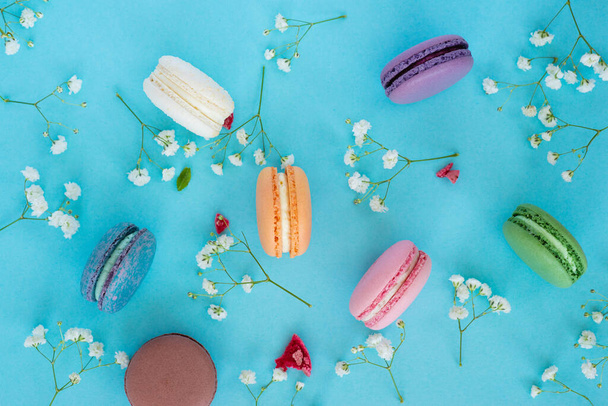 Colourful french macaroons or macarons on pastel floral background. - Foto, imagen