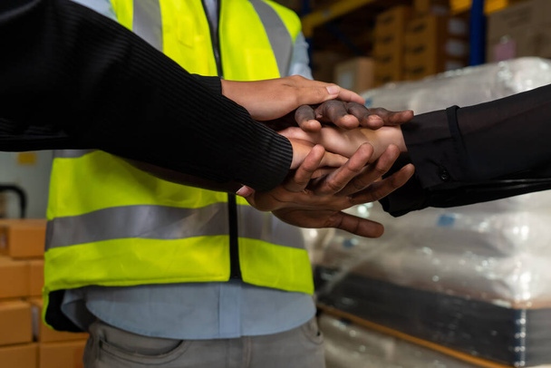 Factory workers stacking hands together in warehouse or storehouse - Φωτογραφία, εικόνα
