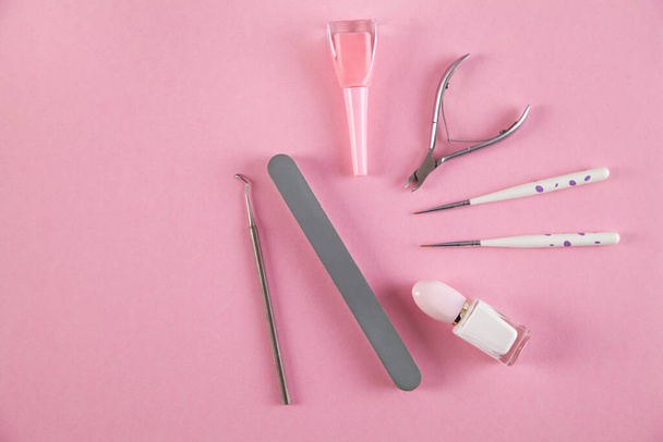Manicure accessoires op een geïsoleerde roze achtergrond. - Foto, afbeelding