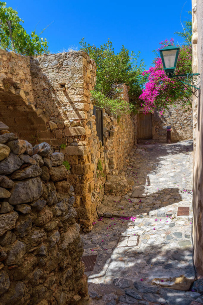 Architecture traditionnelle avec rue étroite en pierre et bougainvilliers colorés dans le château médiéval de Monemvasia, Lakonia, Péloponnèse, Grèce. - Photo, image