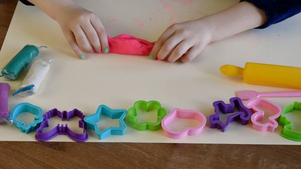 Bebek elleri plastik kalıplar ve oklavalarla renkli oyun hamuru oynuyor - Fotoğraf, Görsel