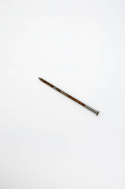 A single rusty nail on white background - Fotoğraf, Görsel