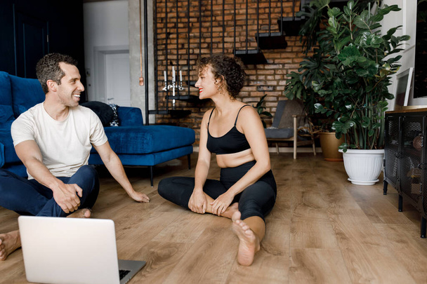 young couple training  at home with  laptop on the floor - Φωτογραφία, εικόνα