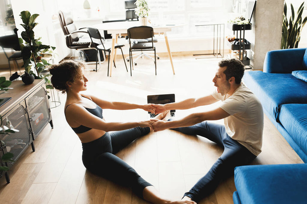 young couple training  at home with  laptop on the floor - Photo, Image