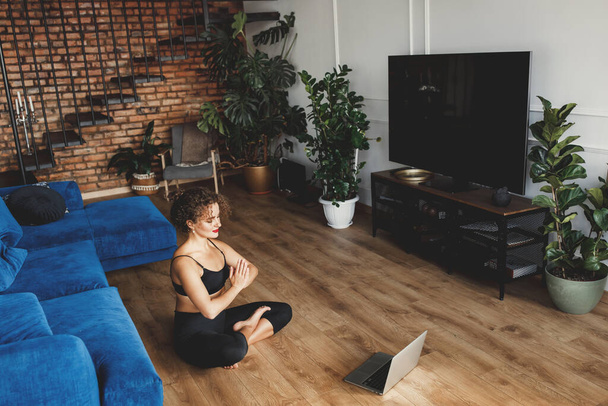 красива молода жінка займається вправами йоги у вітальні
 - Фото, зображення