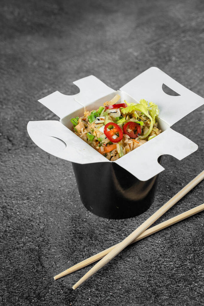 米は食料供給のために箱に入れられている。通りのレストランやファーストフードカフェのためのアジアのスパイシーな料理. - 写真・画像
