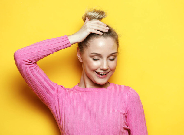 Young and cheerful blonde woman smiling and laughing looking at the camera over yellow background - Fotó, kép