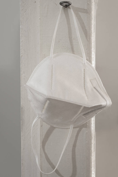  A white protective mask, hung after use. Protection mask against infectious diseases. - Photo, Image