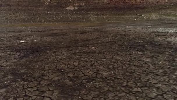 Luchtfoto van een bodem van een gedroogd meer, concept van opwarming van de aarde en klimaatramp. Neergeschoten. Droge bruine grond met diepe scheuren. - Video