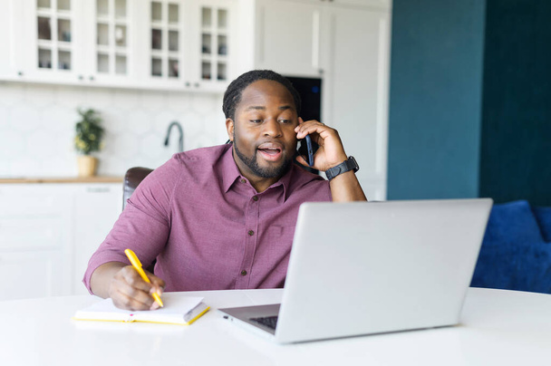 Multitasking and busy African-American male entrepreneur using laptop computer - Fotografie, Obrázek