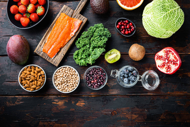 Dieta equilibrada alimentos orgánicos saludables selección limpia, plano sobre fondo de madera oscura, con espacio para el texto. - Foto, imagen