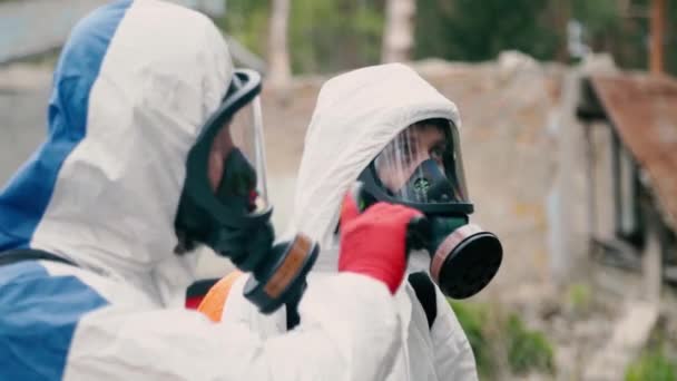 I lavoratori della disinfezione parlano vicino ai vecchi edifici abbandonati - Filmati, video