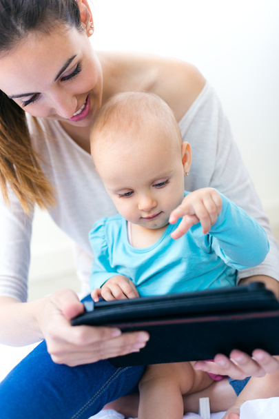 Mother and baby girl using digital tablet at home  - Foto, Imagem