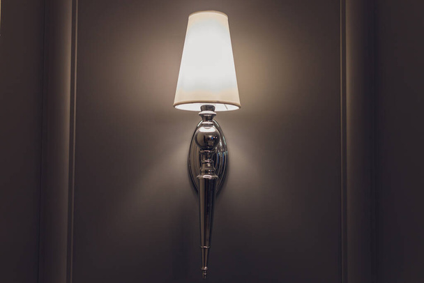 Modern wall lamp on a light wall. Free space and decor in the interior. - Foto, imagen