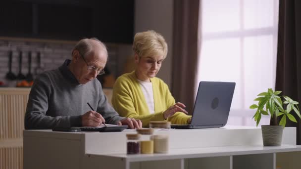 úklid a výpočet rodinného rozpočtu, manželé důchodci počítají společně v kuchyni - Záběry, video