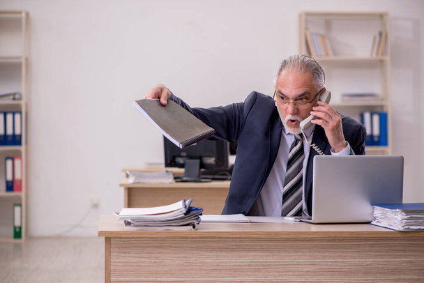 Aged businessman employee sitting in the office - Photo, image